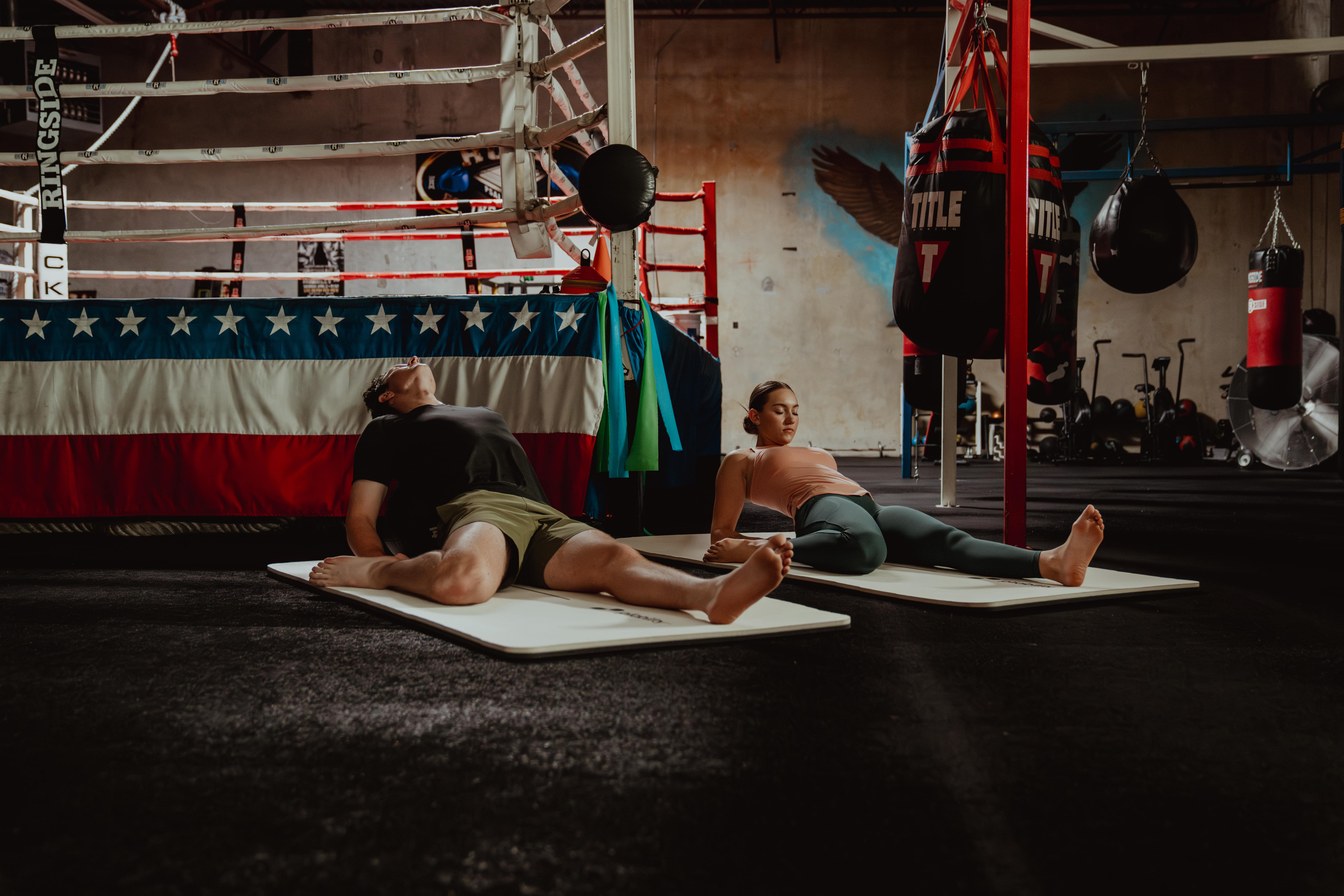 man stretching with team mate -  gluteus medius stretch