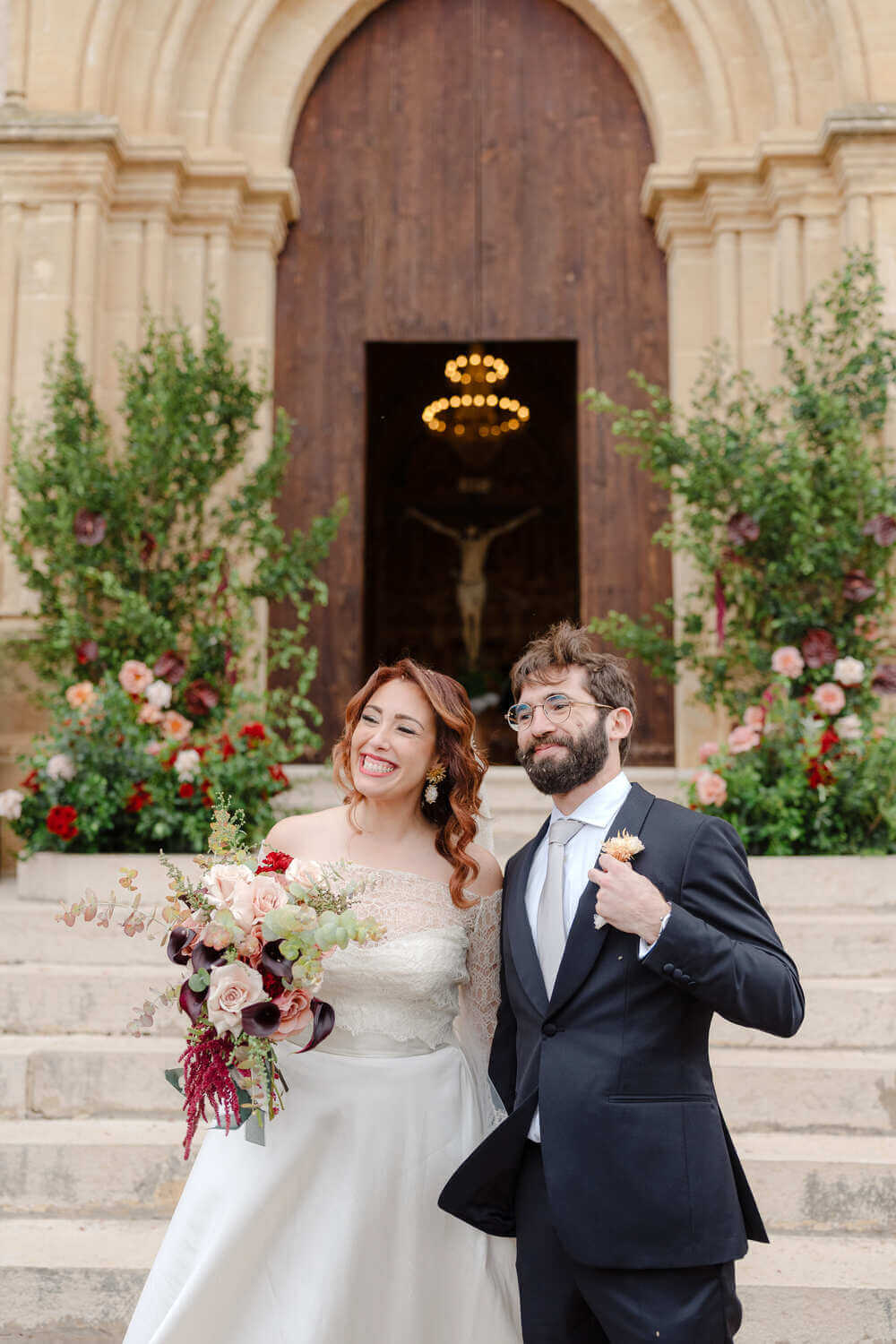 A bride in a lace wedding dress gently holds.