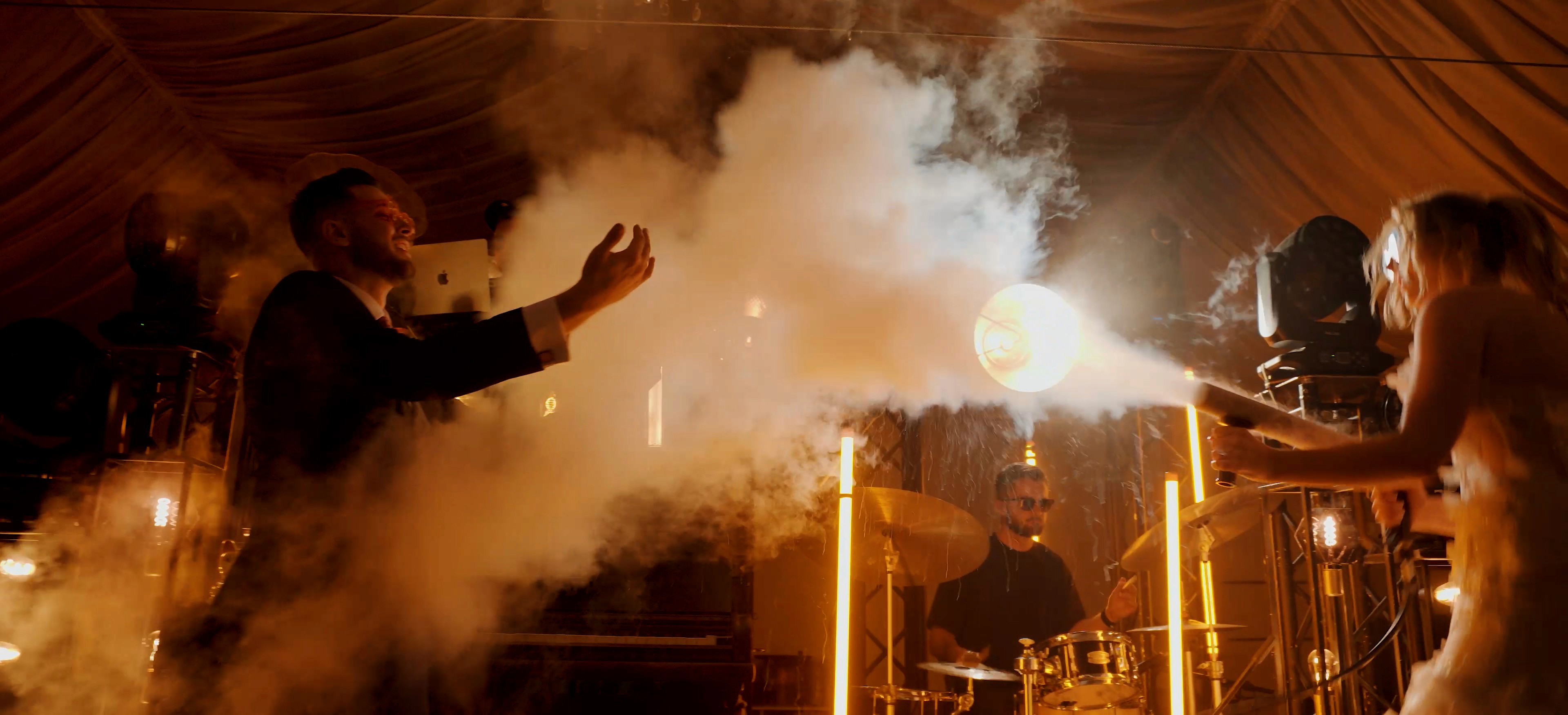 A joyful couple stands back-to-back outdoors.
