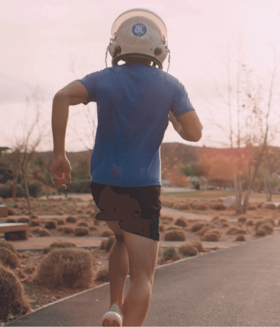 Runner wearing astronaut helmet jogging on a trail, visualizing space-inspired performance for Brooks Aurora running shoe campaign.