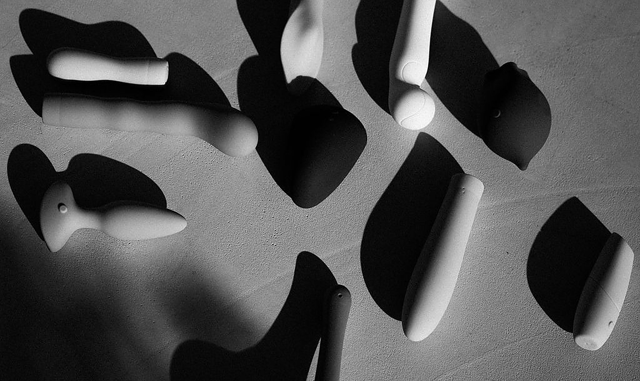 An editorial flat-lay of intimacy products in soft light and shadow, exploring tools that can help awaken your desire | My Temple