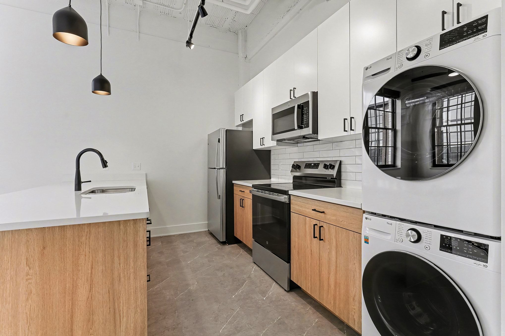 A gym room featuring several treadmills and a large window allowing natural light to enter.