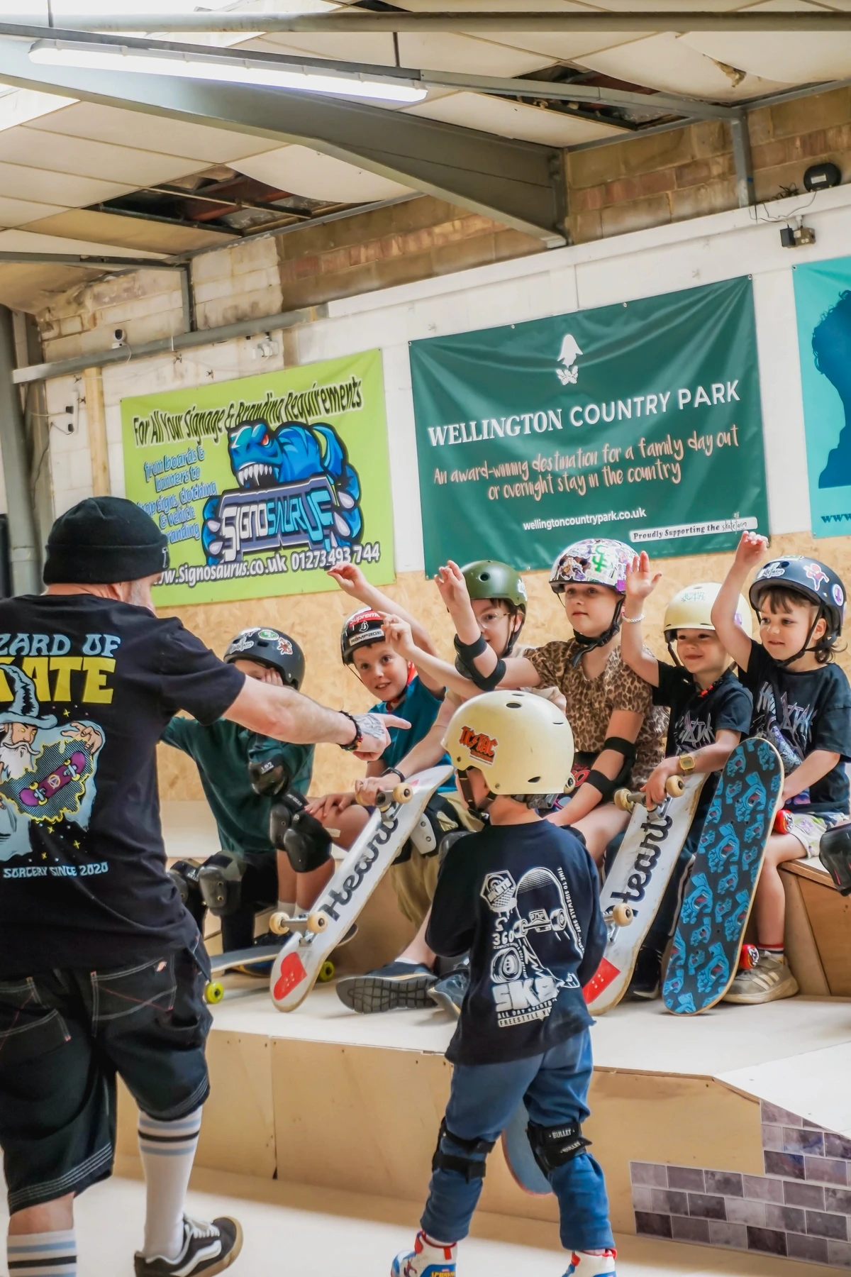 A skate coach celebrating with a group of young children at a birthday party at The Skate Farm indoor skatepark in Haywards Heath