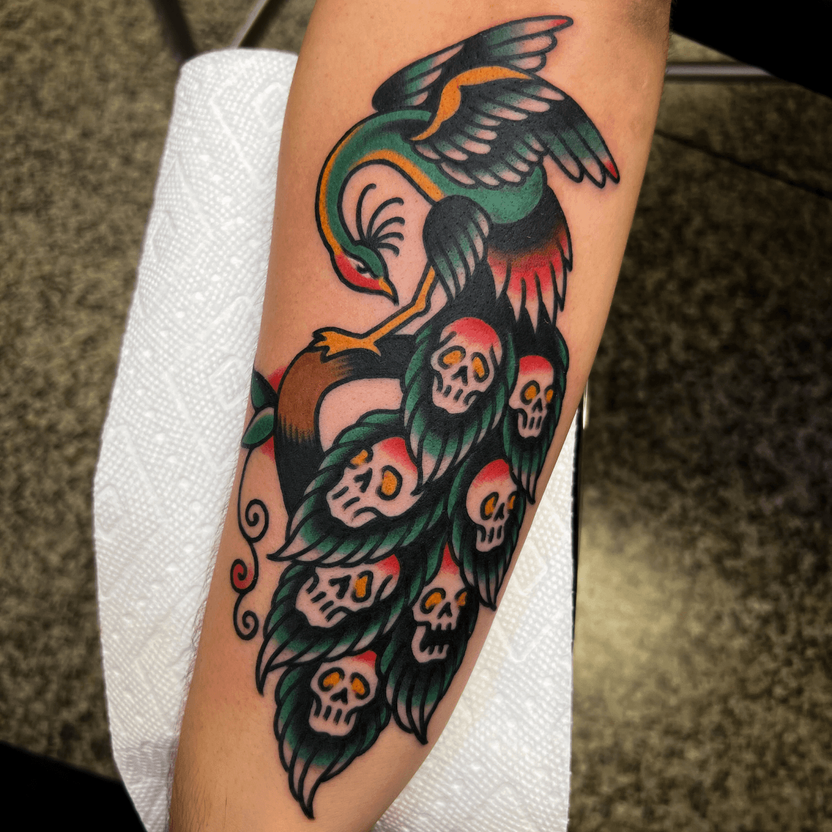 color tattoo of a peacock with skulls in it's tail feathers