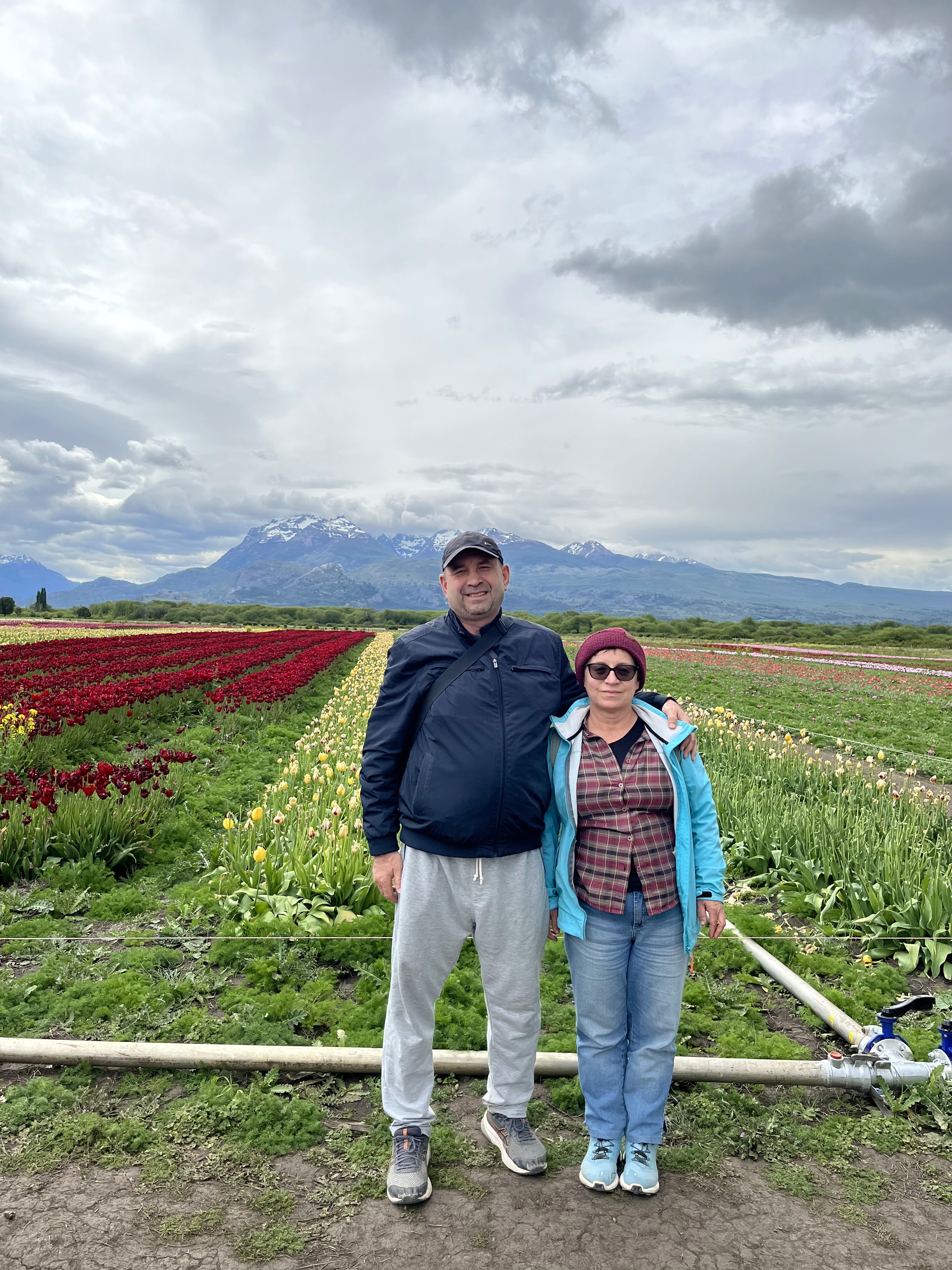 Mujer sentada sobre un tronco frente a una cascada doble en un bosque frondoso de Argentina.