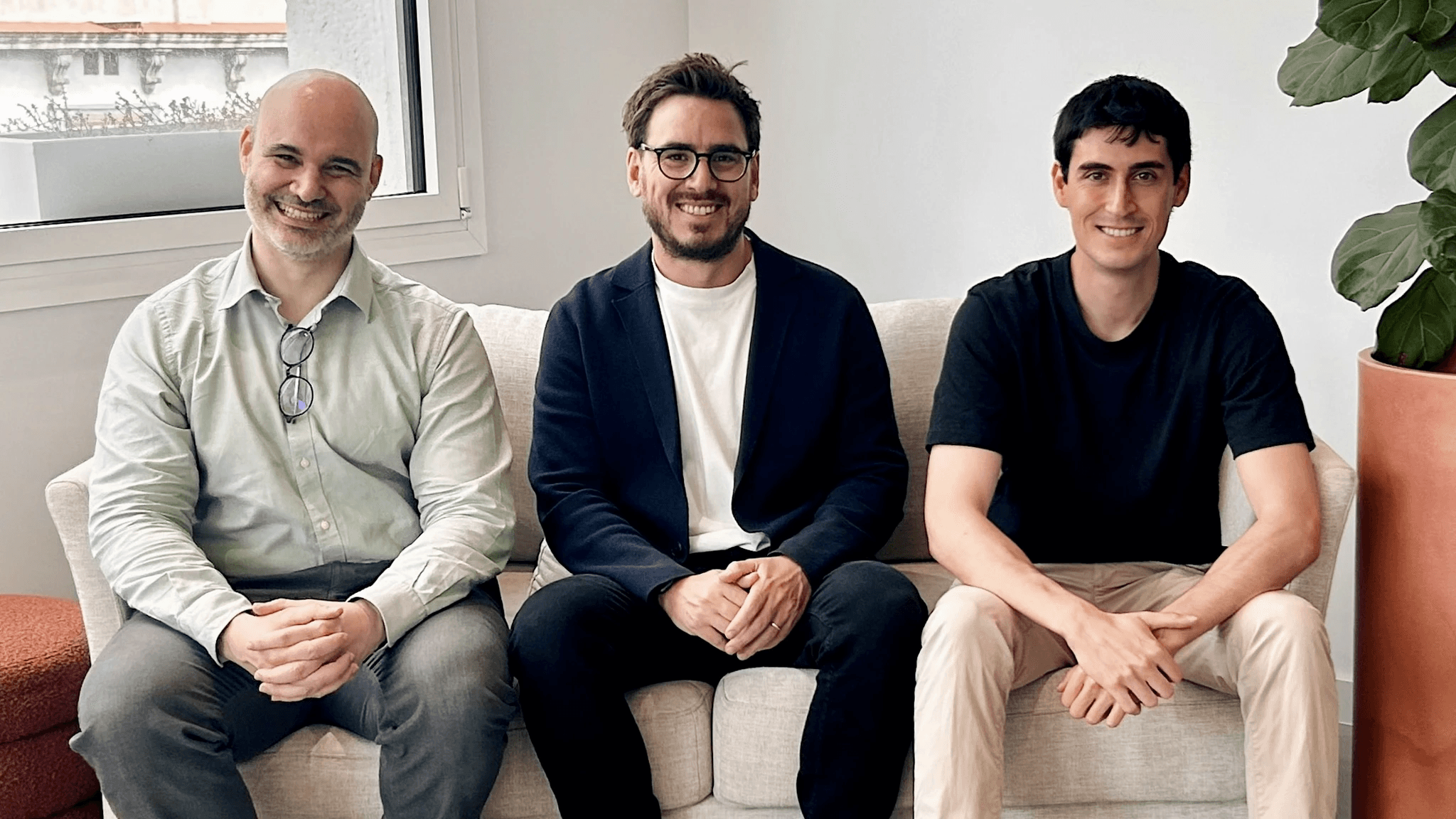 Equipo de Ratio sentado en un sofá, sonriendo a cámara.