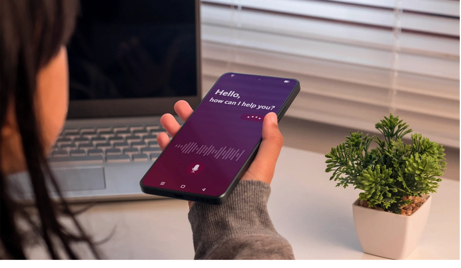 A young girl holding a smartphone to use virtual voice assistant