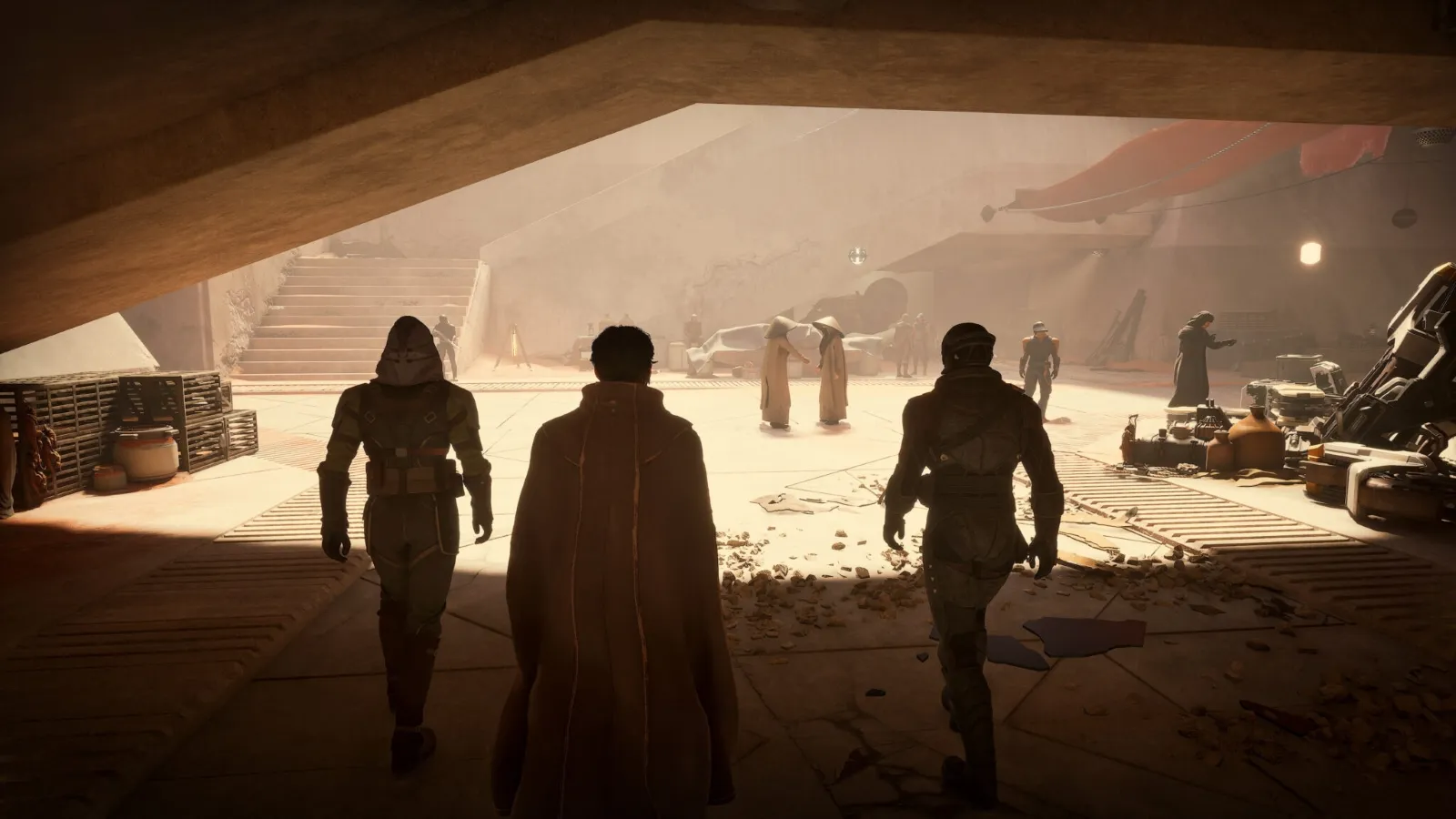 A group of hooded figures and individuals wearing cloaks walk through a dimly lit, futuristic underground space, featuring industrial décor and scattered debris.
