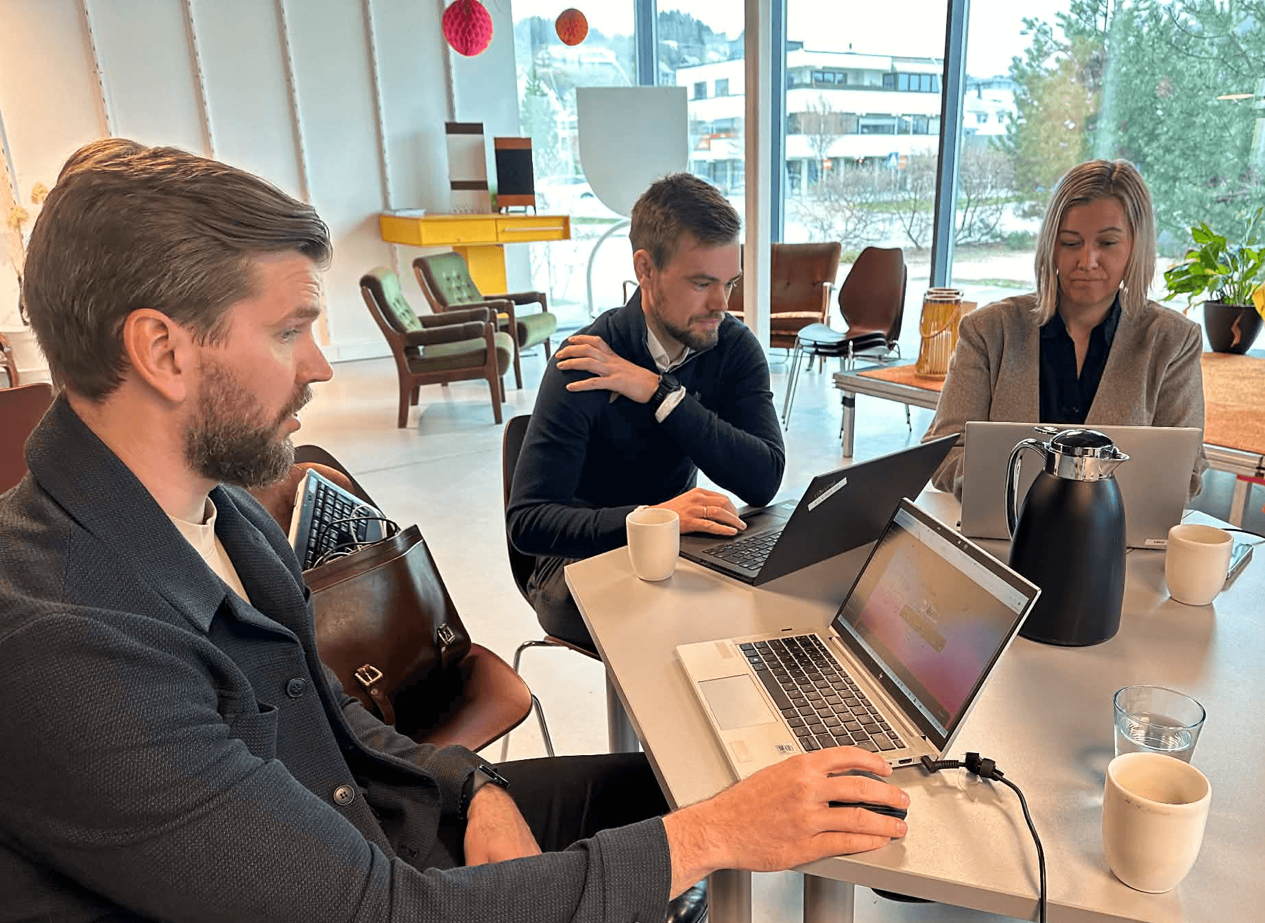 A person wearing a virtual reality headset stands in front of multiple screens, engaged in a digital experience.
