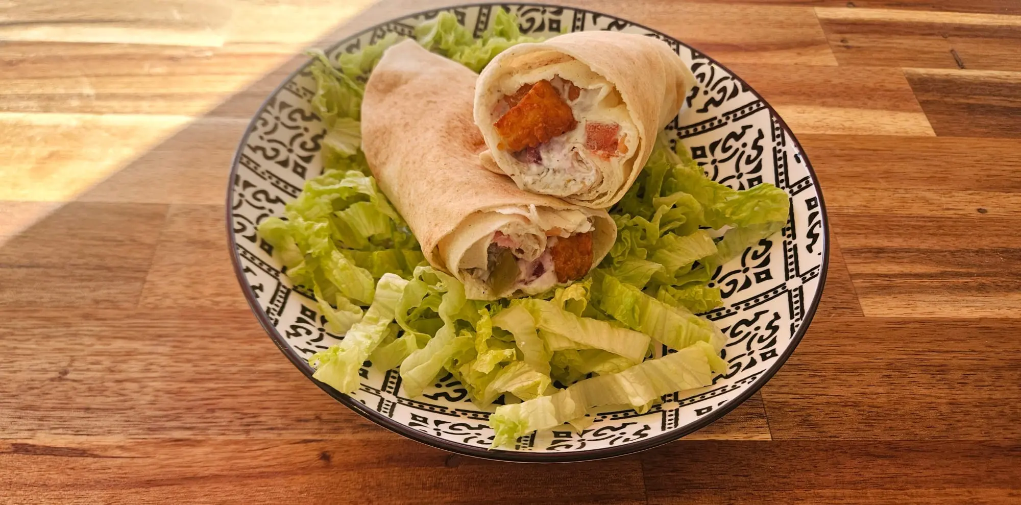 Sandwich au fromage posé sur une assiette noire, accompagné de salade