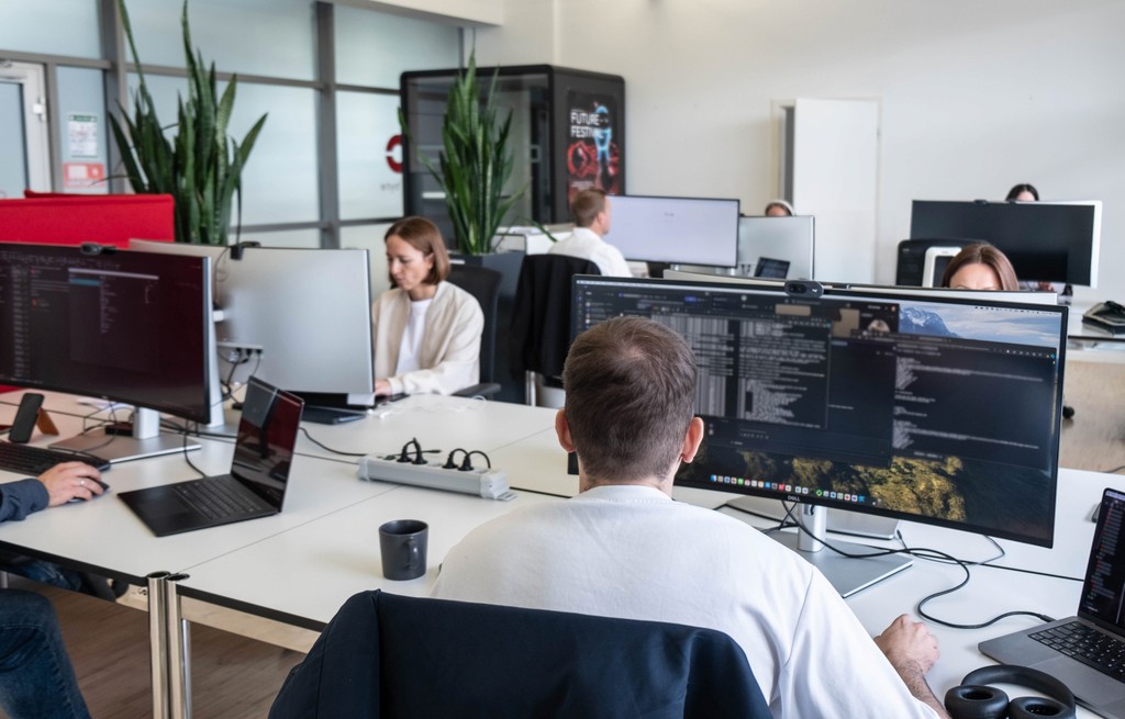 CarByte Mitarbeitende im Büro arbeiten an großen Bildschirmen