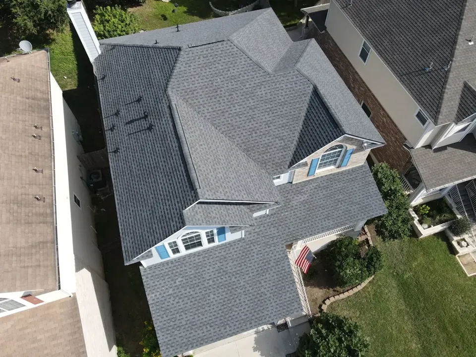 Completed Pewter Grey GAF Timberline HDZ roof on a San Marcos home with blue shutters, 2024.