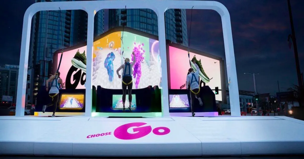 a man walking down a street past a large poster
