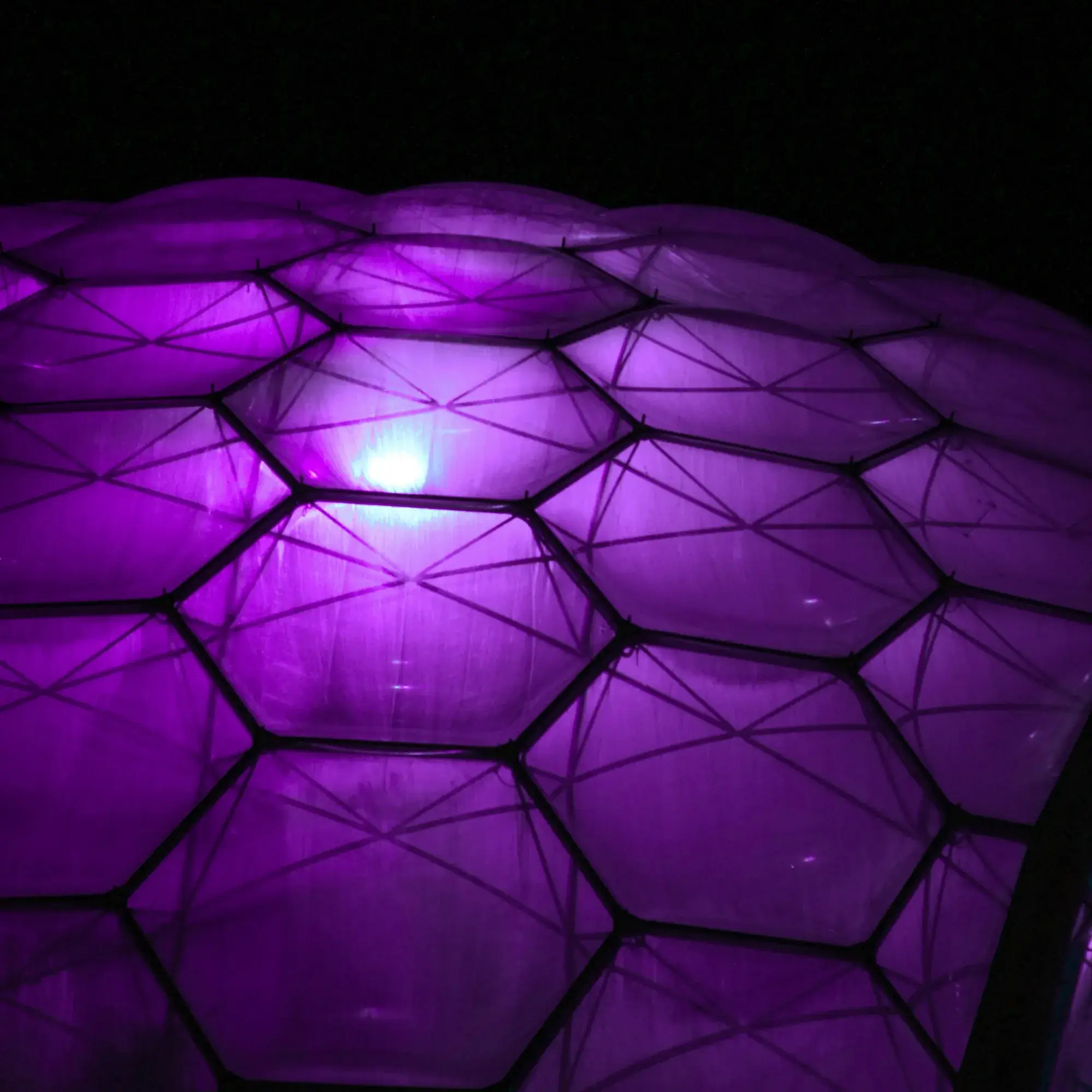 a purple light shines brightly on the surface of a building