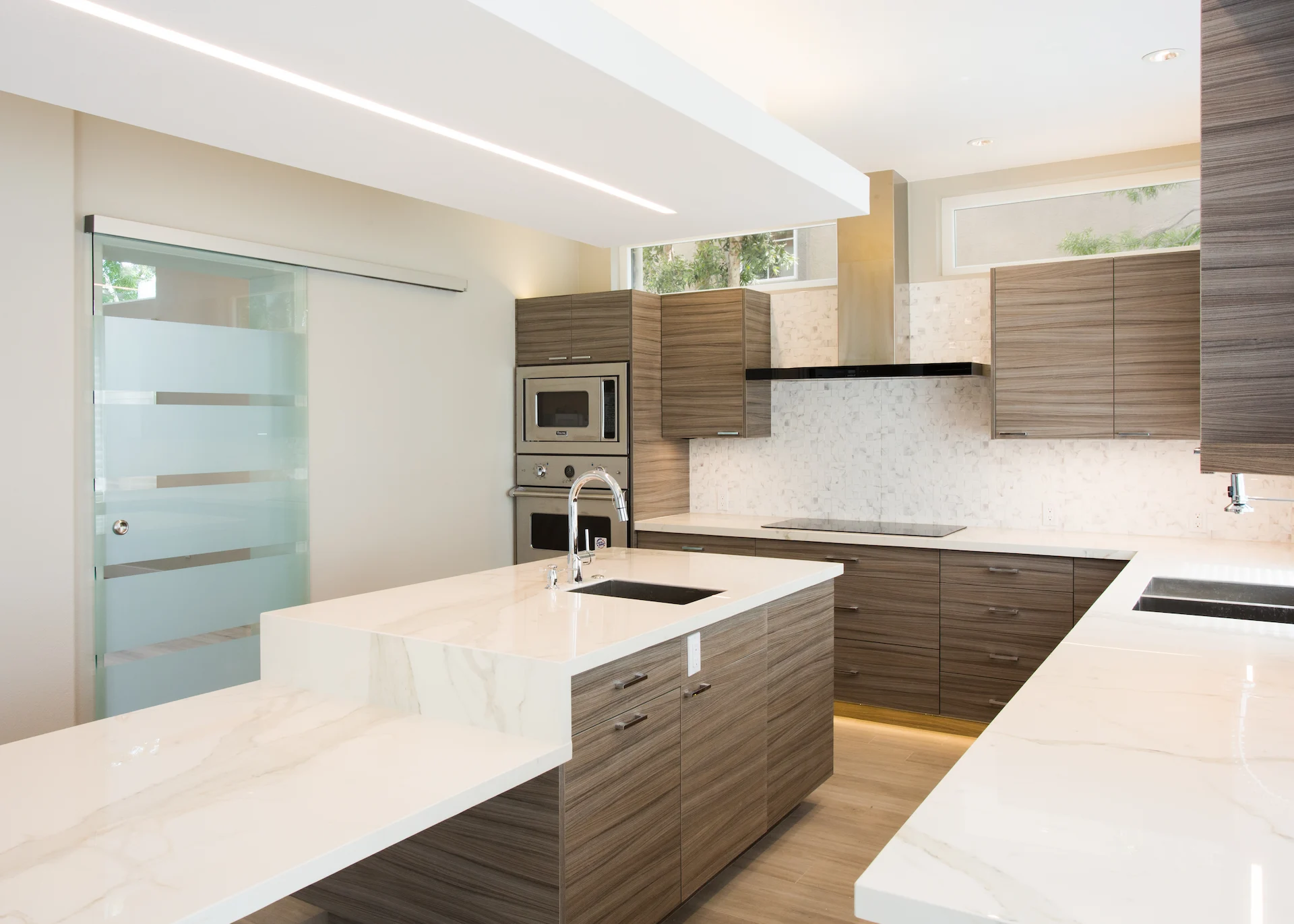 View of the kitchen island and range wall at an angle, highlighting the sleek design and modern appliances in this Harbor Cove kitchen.