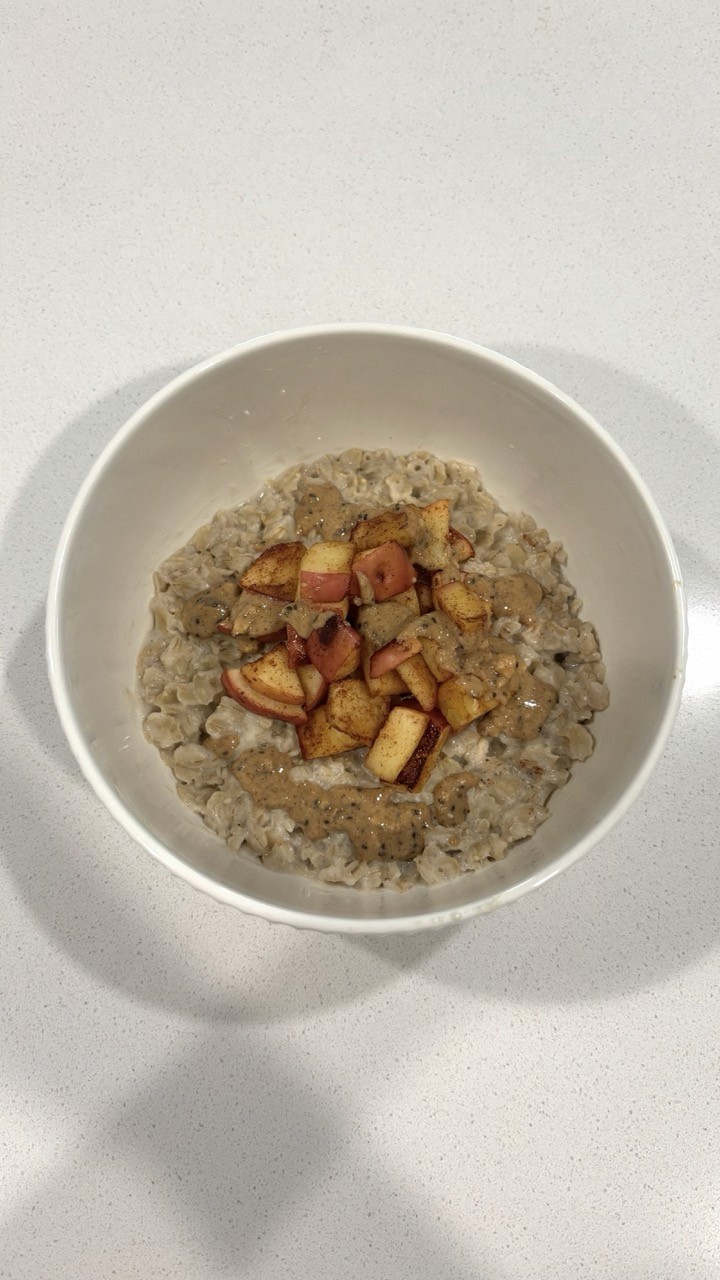 Creamy oatmeal topped with cinnamon sautéed apples and nut butter – warm apple cinnamon oatmeal breakfast Wellness by Suhey