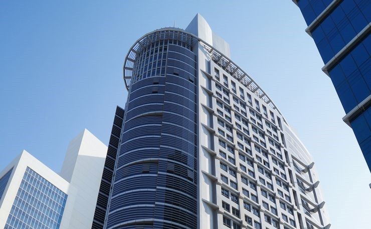 Looking up at the iconic Silver Tower skyscraper, a landmark for high-end business real estate in Dubai.