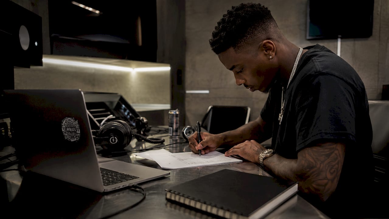 Hip-hop artist signing split sheet at desk