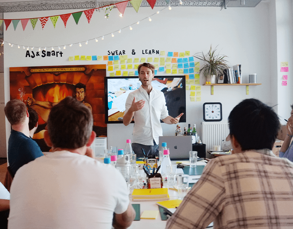 AJ&Smart facilitator leading a Design Sprint workshop with sticky notes and participants