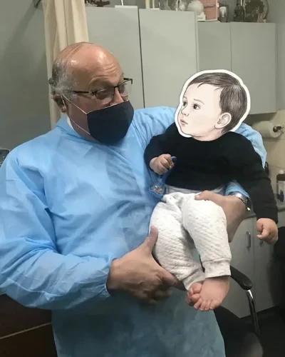 Dr. Ashraf Saddik sharing a gentle moment, looking at an infant patient at The Circumcision Doctor clinic in Melbourne.