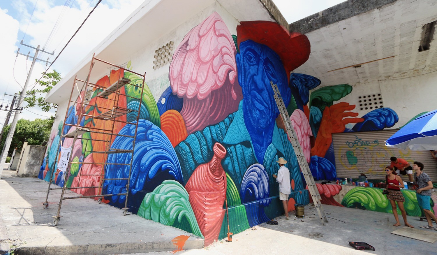 Jason Botkin painting mural details on the Jacques Cousteau wall in Cozumel