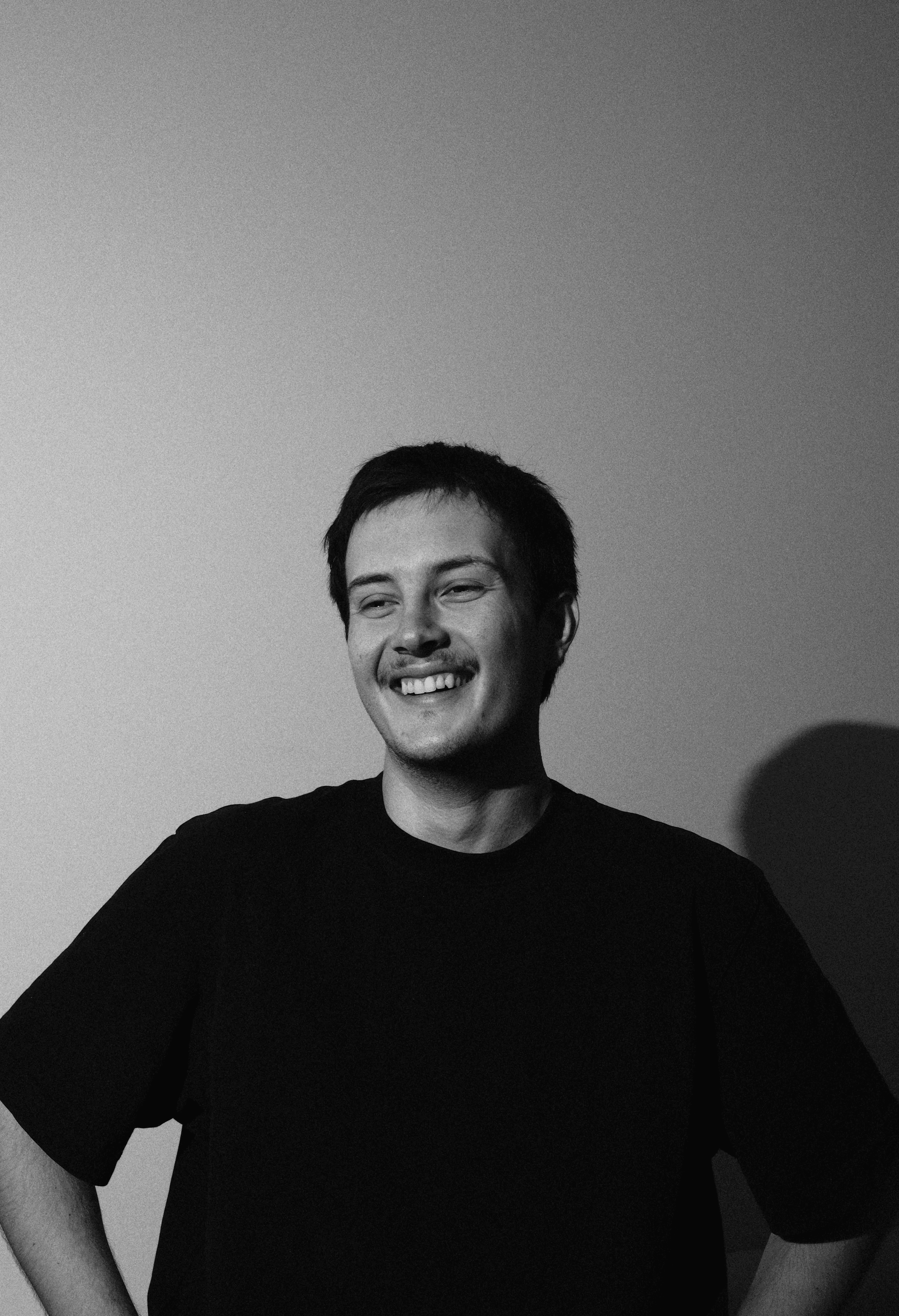 Black-and-white portrait of Aydin Genchsoy smiling