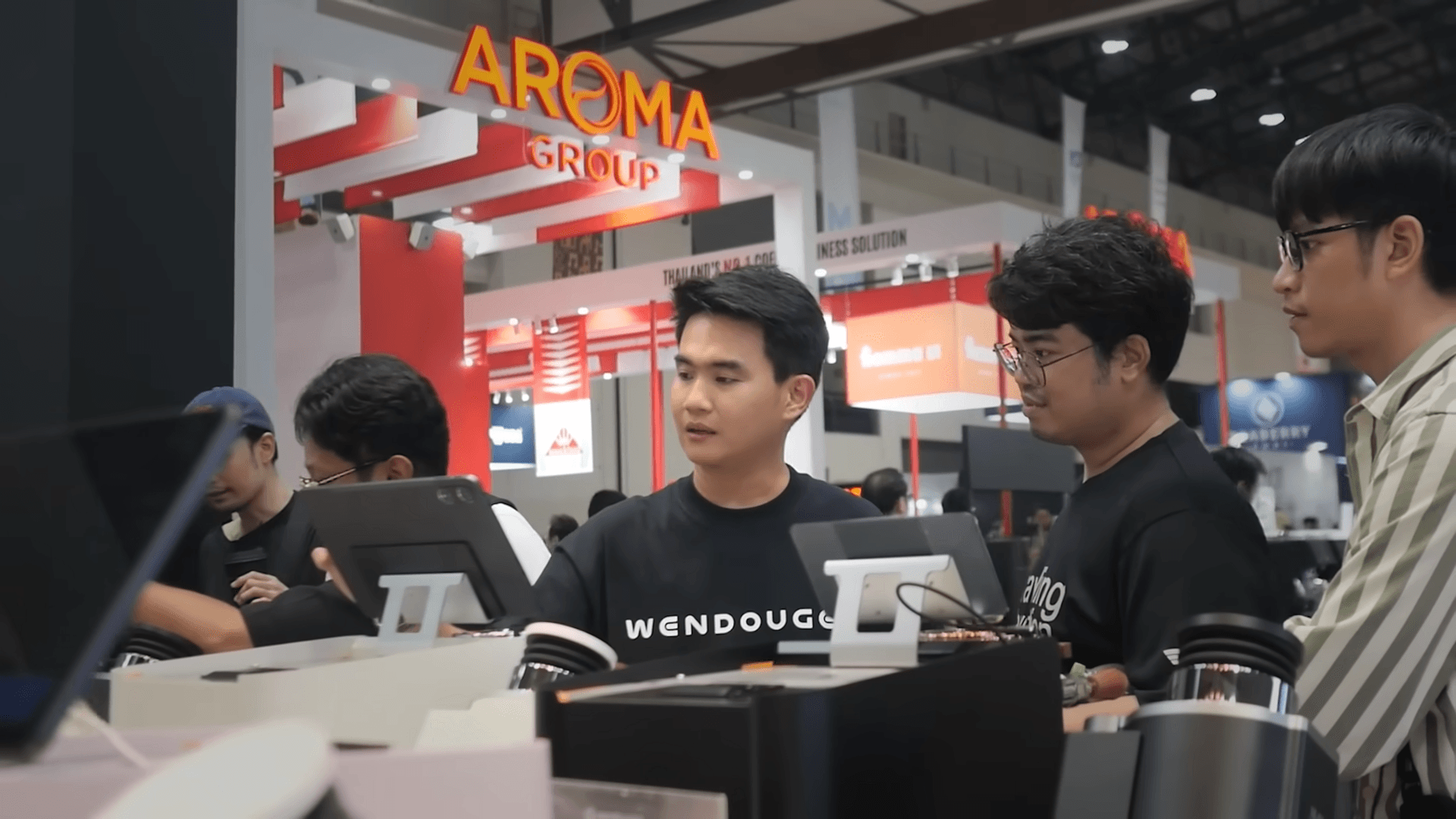 CEO ยืนอธิบายการใช้งานเครื่องชงในงานอีเวนต์