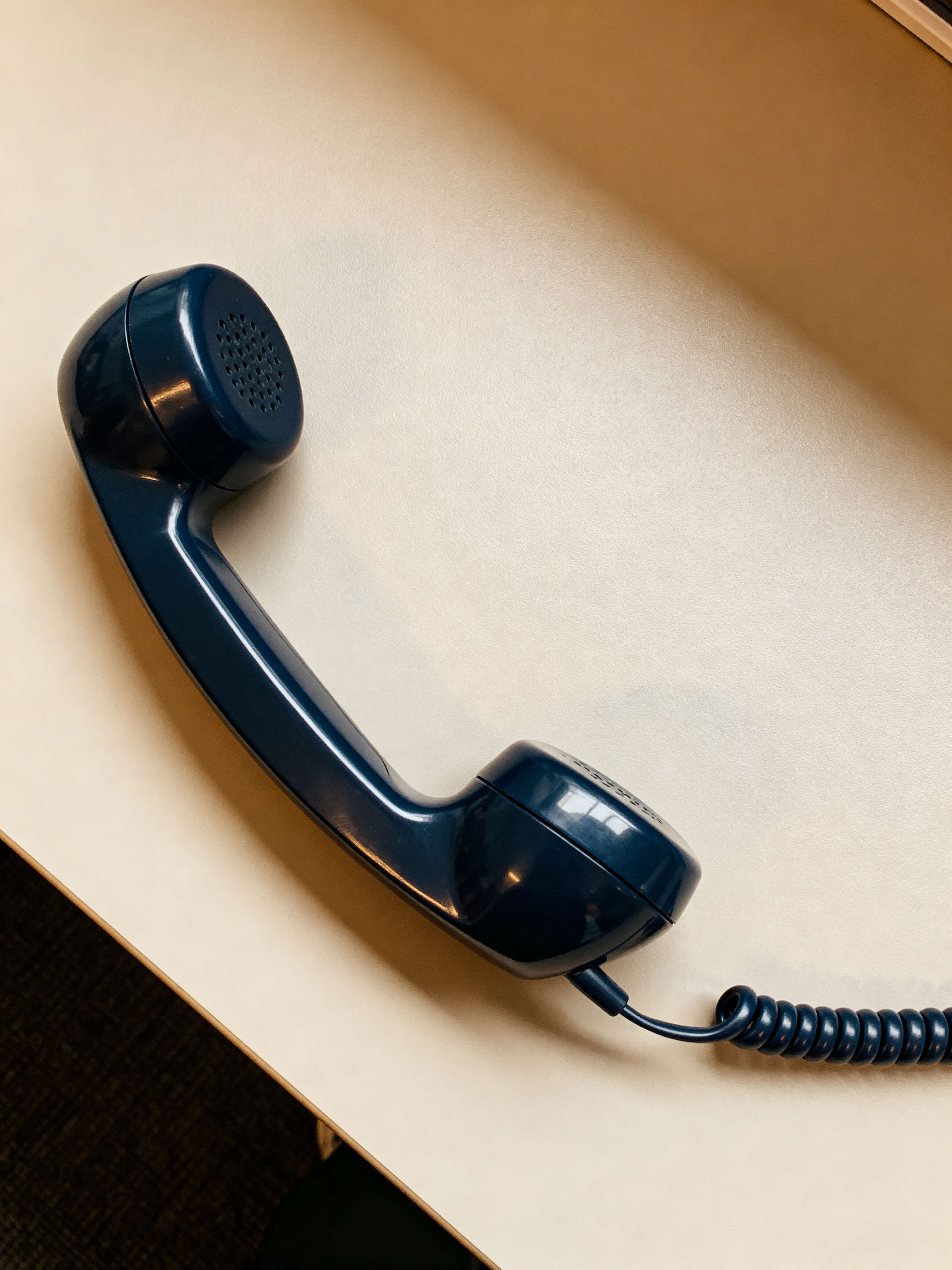Telefone vintage com fio sobre superfície neutra com luz natural, representando o primeiro contato para contratação de palestra.