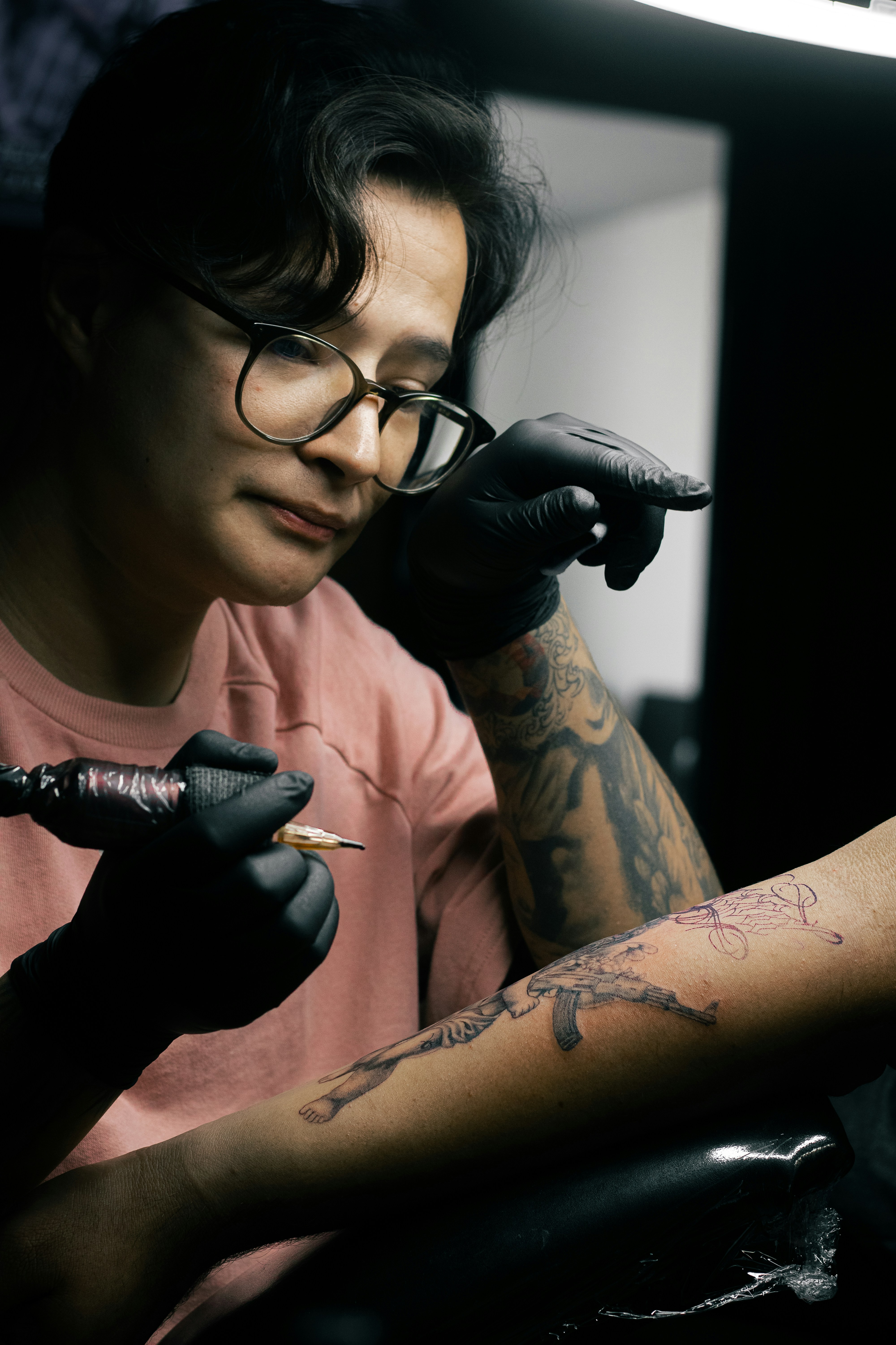 A tattoo artist is inking a design.