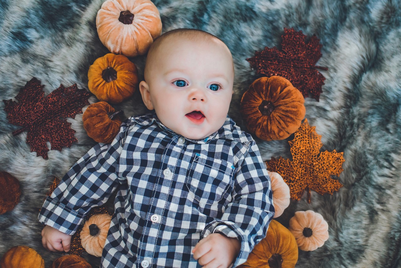 Bride in a lace wedding dress holding a vibrant bouquet of flowers on stone steps.