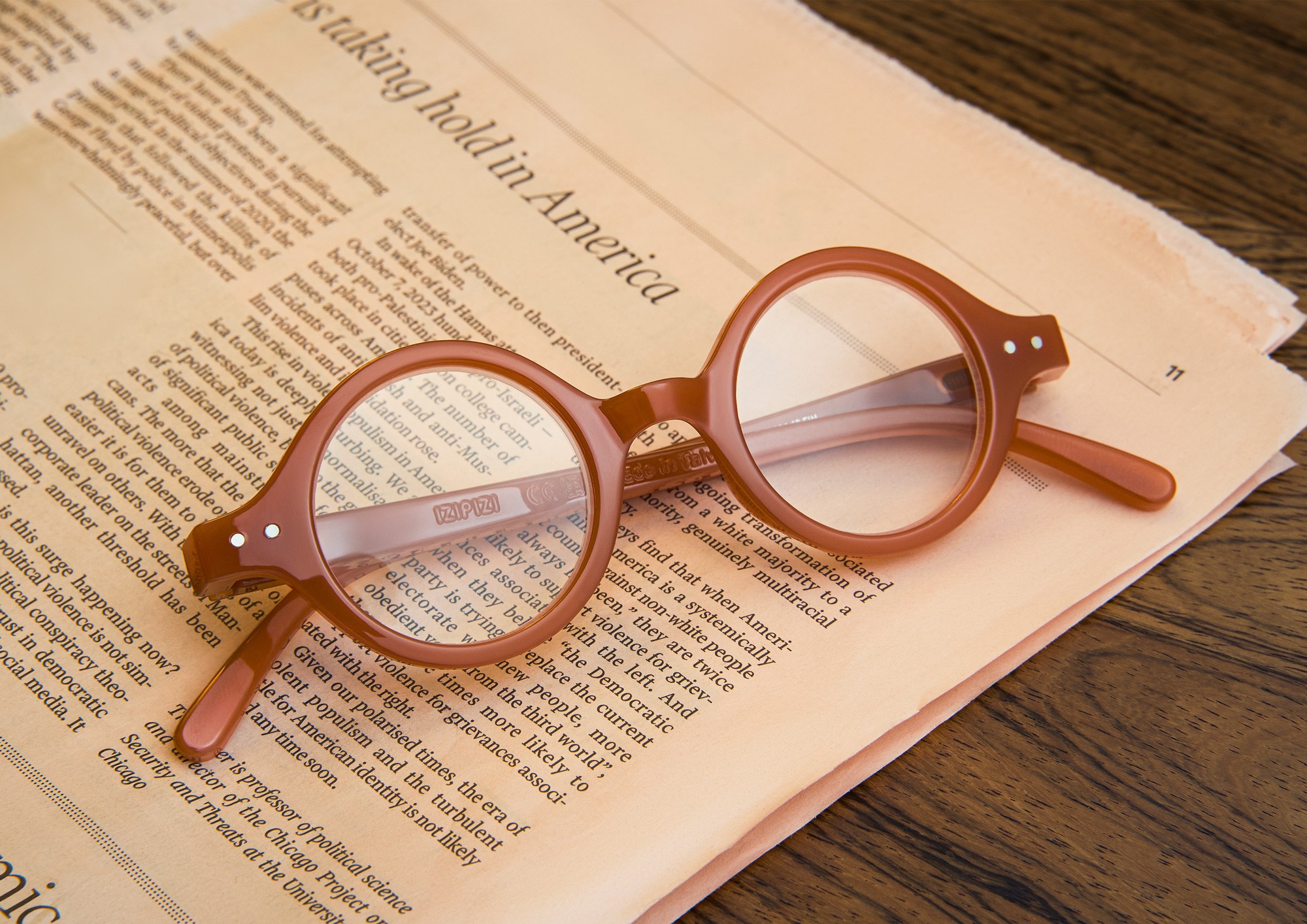 Brown Izipizi glasses resting on a newspaper photographed by Matthew Brown.