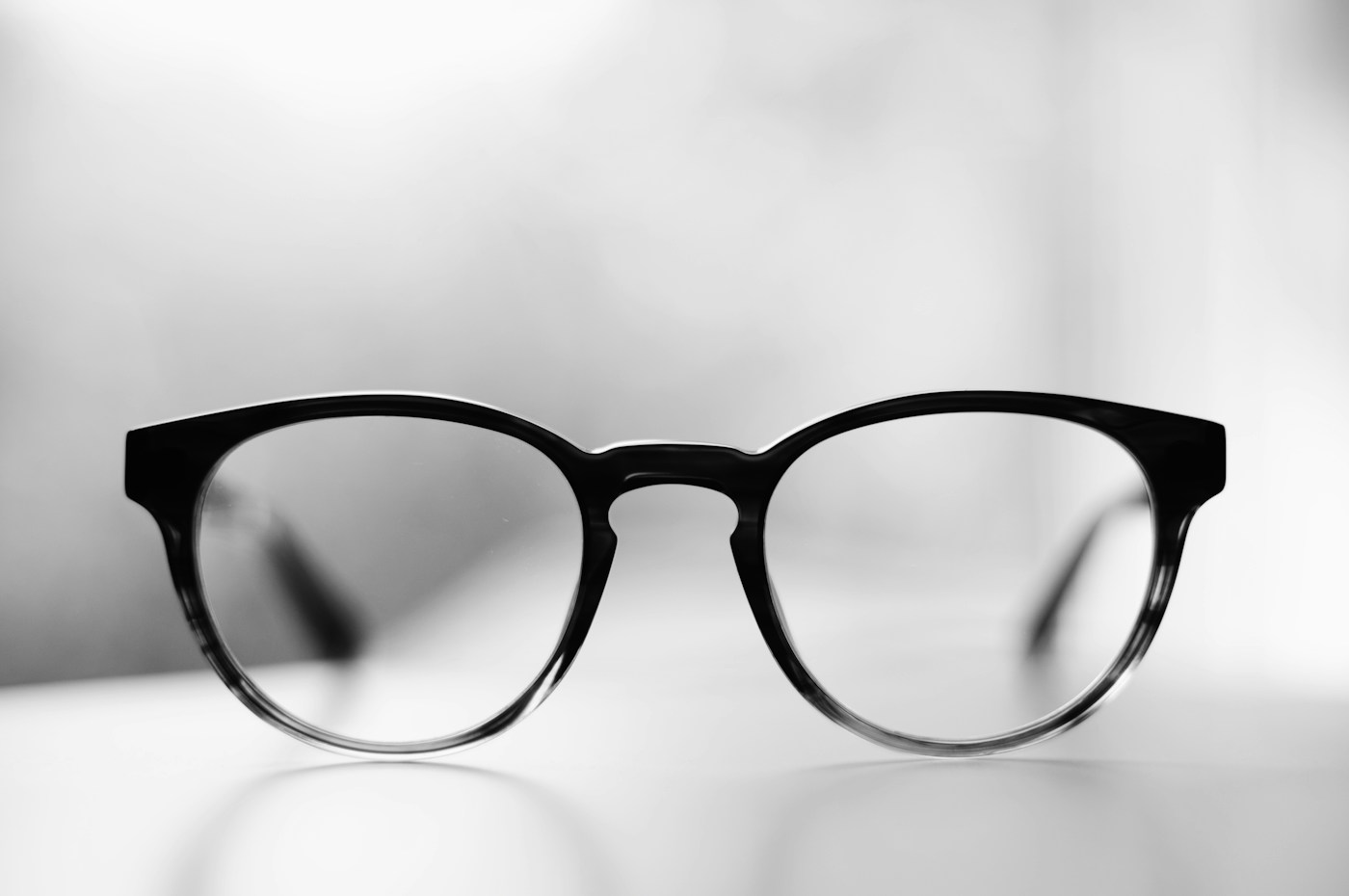Black panto glasses fading to clear at the bottom of the rims, shot in soft light