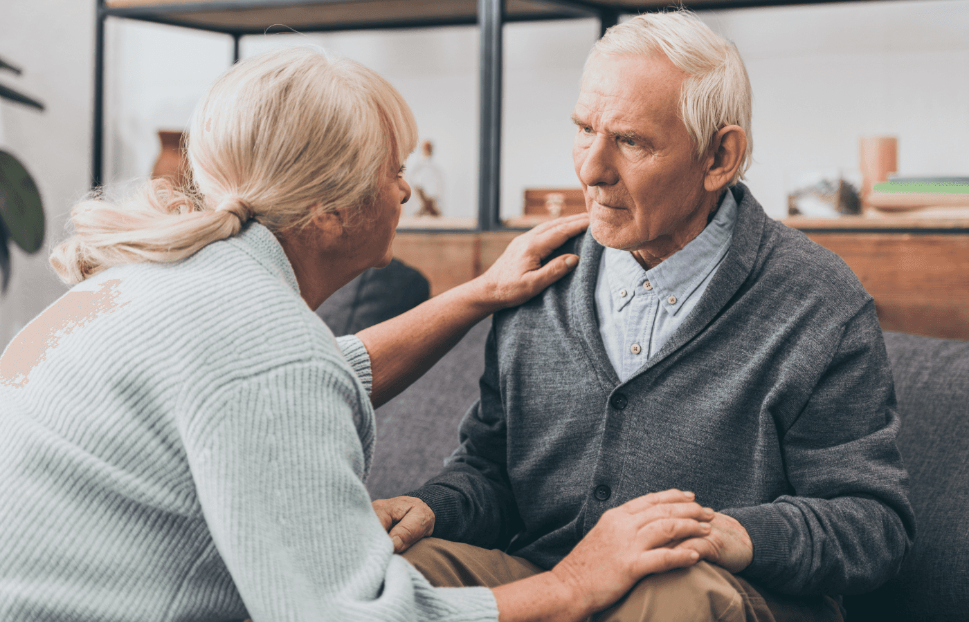 retired couple holding hands and looking at each other at home