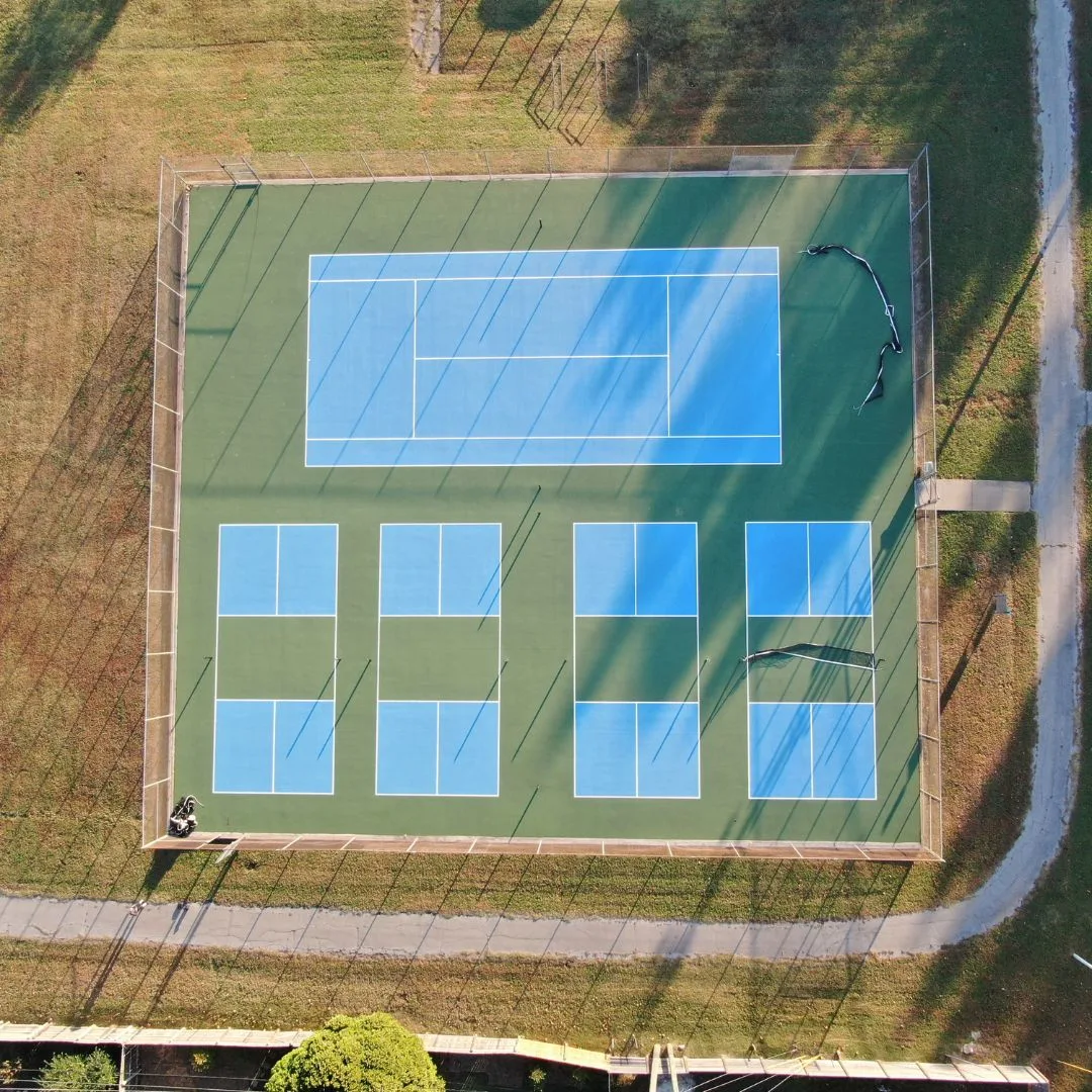 Top-down view of restored multi-use pickleball and tennis court complex in Tulsa with updated striping and smooth playing surface