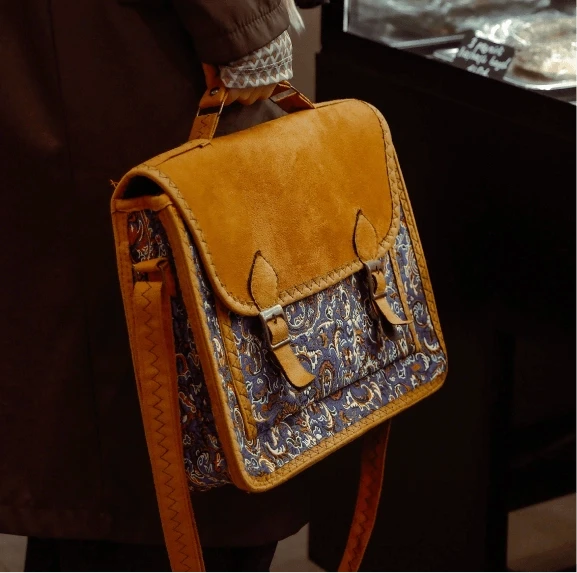 Tan and paisley-print leather satchel bag carried over the shoulder