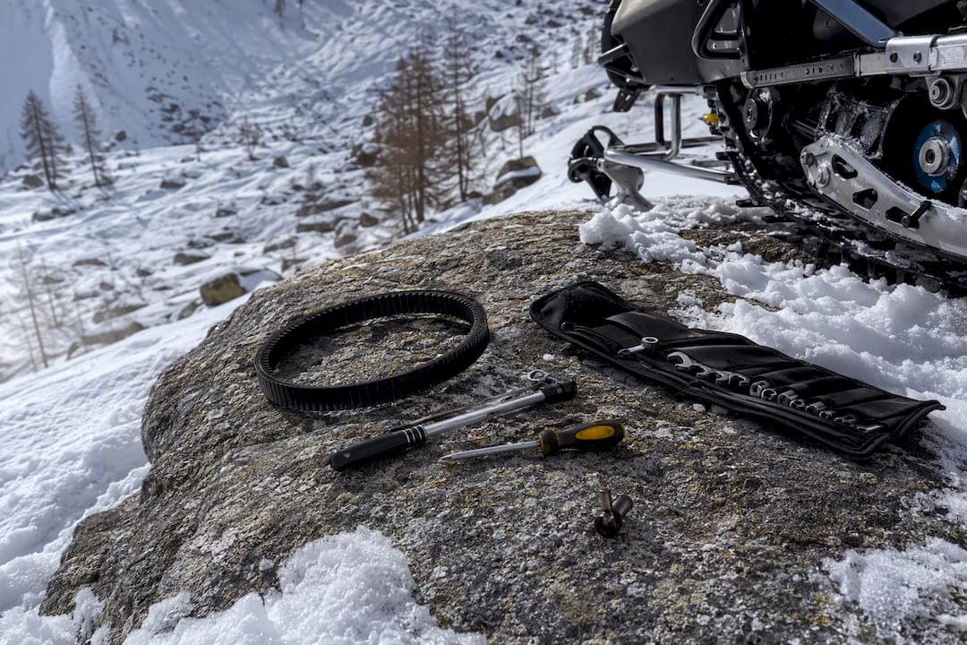 Snowmobile maintenance parts and tools arranged for a pre-ride inspection