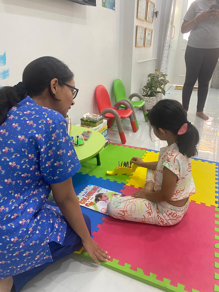 Dr. Urvashi playing with a young child in the clinic’s play area