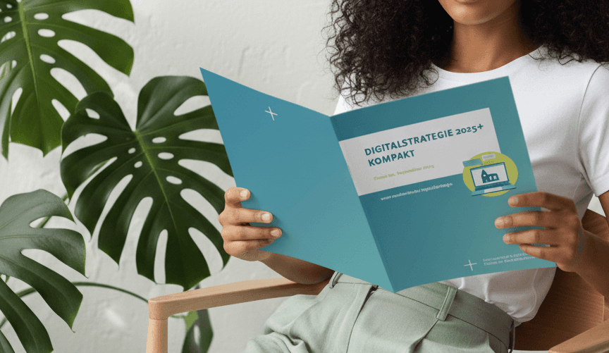 Frau liest die Broschüre „Digitalstrategie 2025+ Kompakt“ auf einem Stuhl.