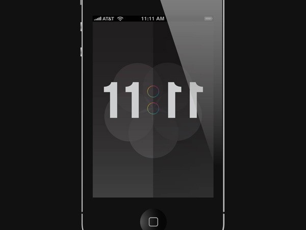 The image shows a black iPhone displaying the time 11:11 on its screen. The time is displayed in white, bold font against a dark gray or black background. The phone's status bar at the top indicates the carrier as AT&T and the time as 11:11 AM. A small circular progress bar with three colored dots (red, green, and blue) is visible below the time, suggesting that the device is in a process or loading state. The phone has a black home button located at the bottom center of the screen. The entire scene is set against a black background.
