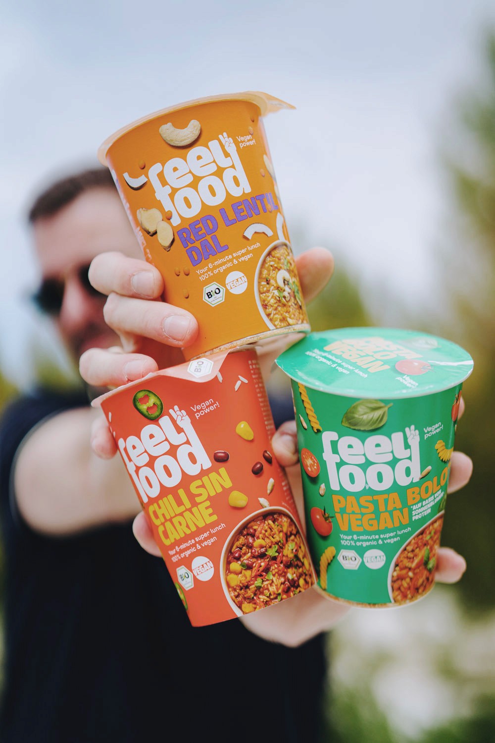 Mann haelt 3 Packungen feelfood