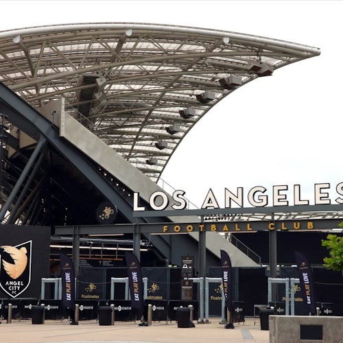 Stadium entrance with "Los Angeles Football Club" signage and a covered structure. Angel City FC logo and banners are visible.