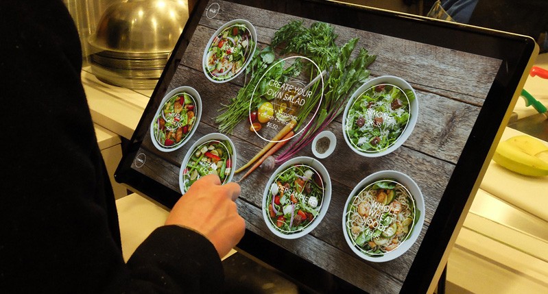 someone is picking a food bowl from a digital menu at the restaurant