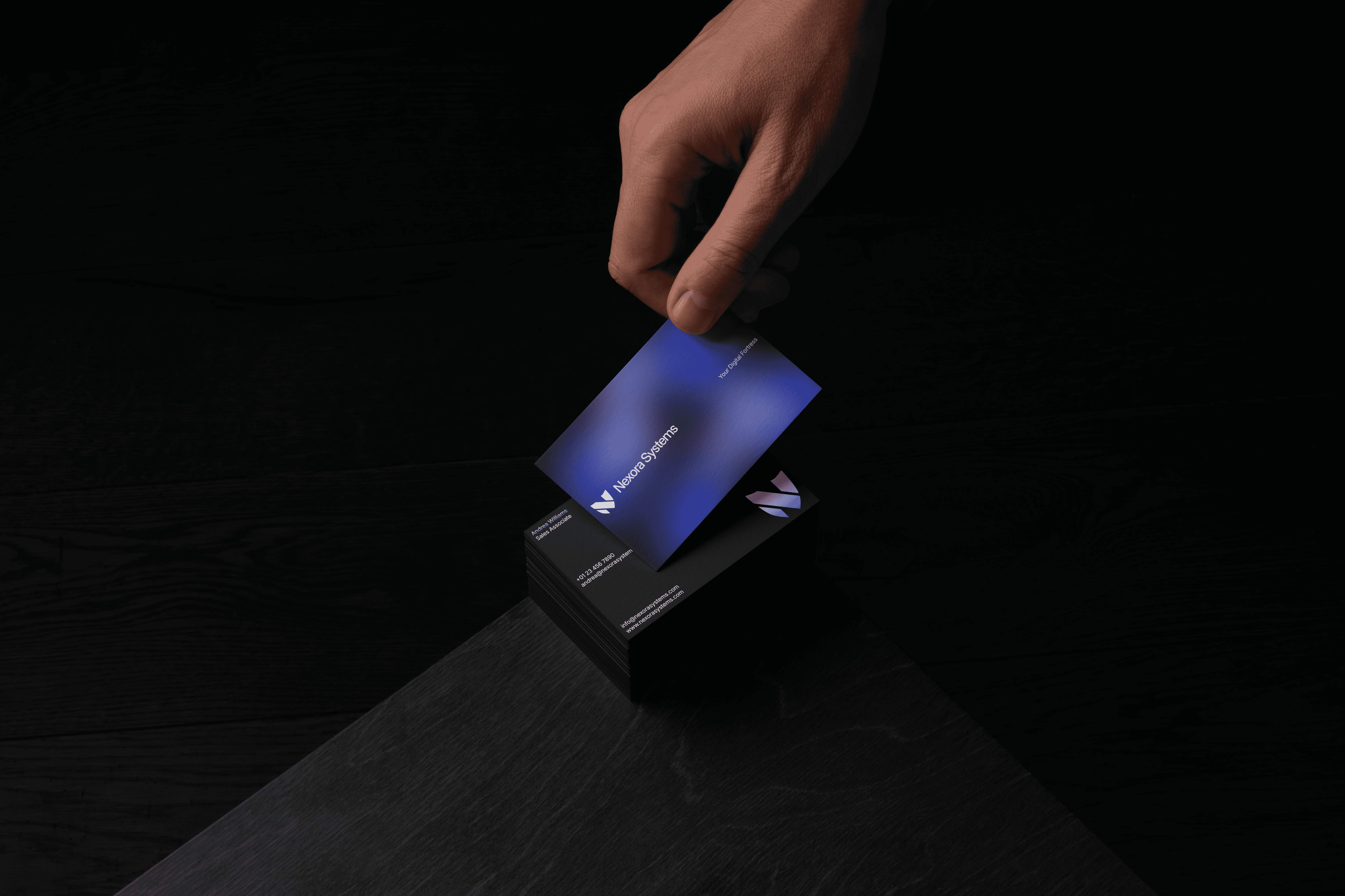 A stack of business cards on a table. The business cards feature a simple, minimalist blue, black, and white design.