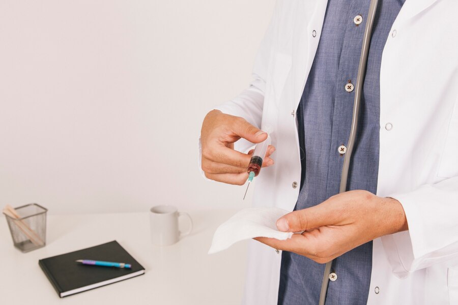 A doctor holding a syringe with a blood saple.