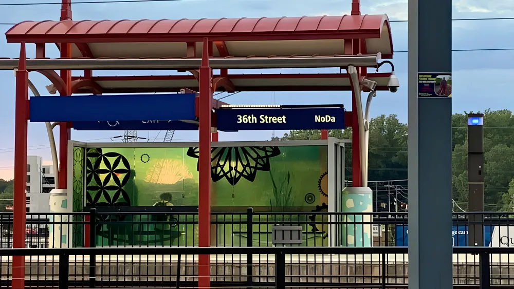 A train station with a striking red and white canopy providing shelter for passengers.