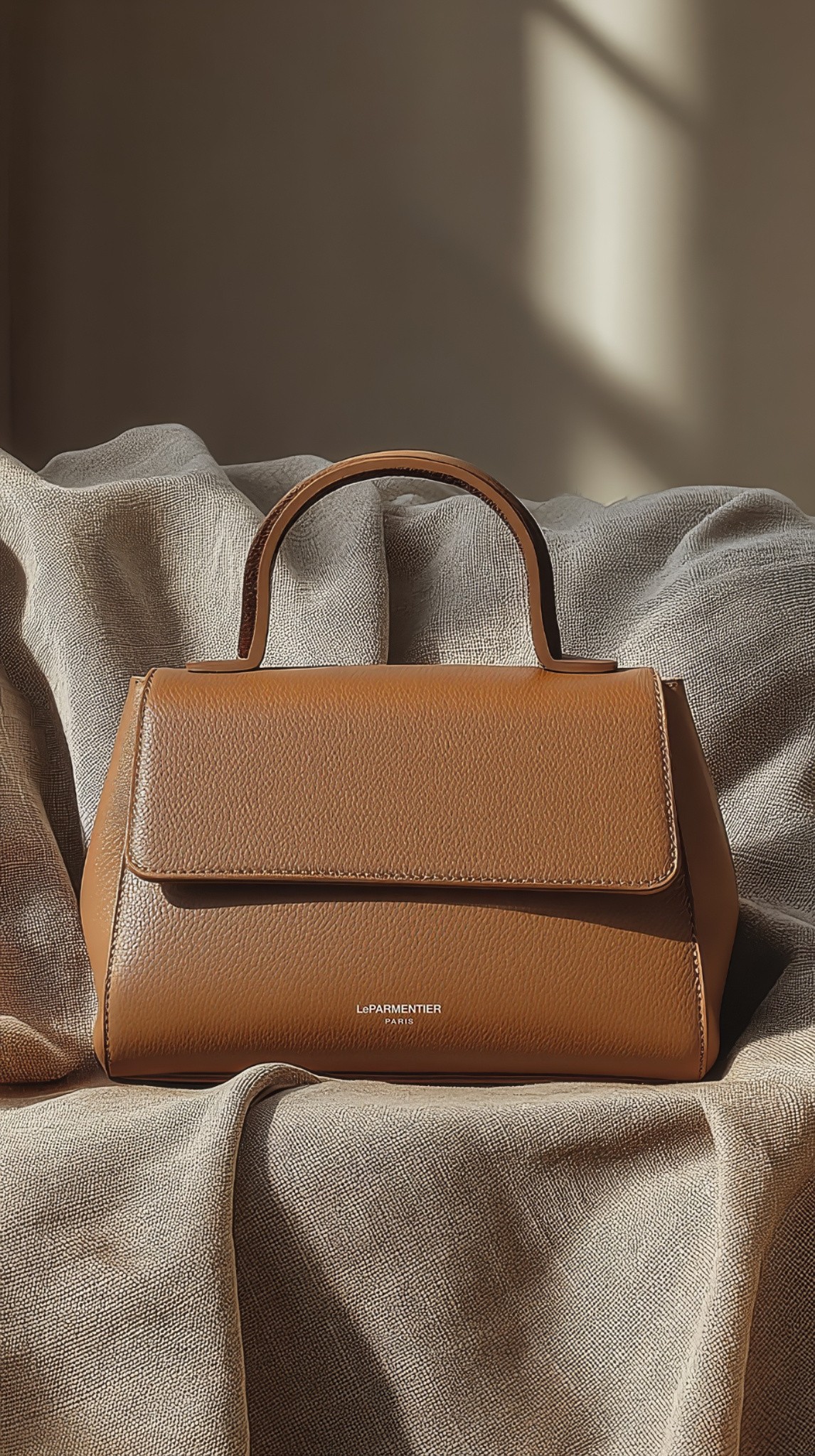 AI fashion visual of a woman in a minimalist beige blazer and dress holding a camel leather handbag, created by Myrovia Labs for LeParmentier. AI branding and product photography for luxury accessories.