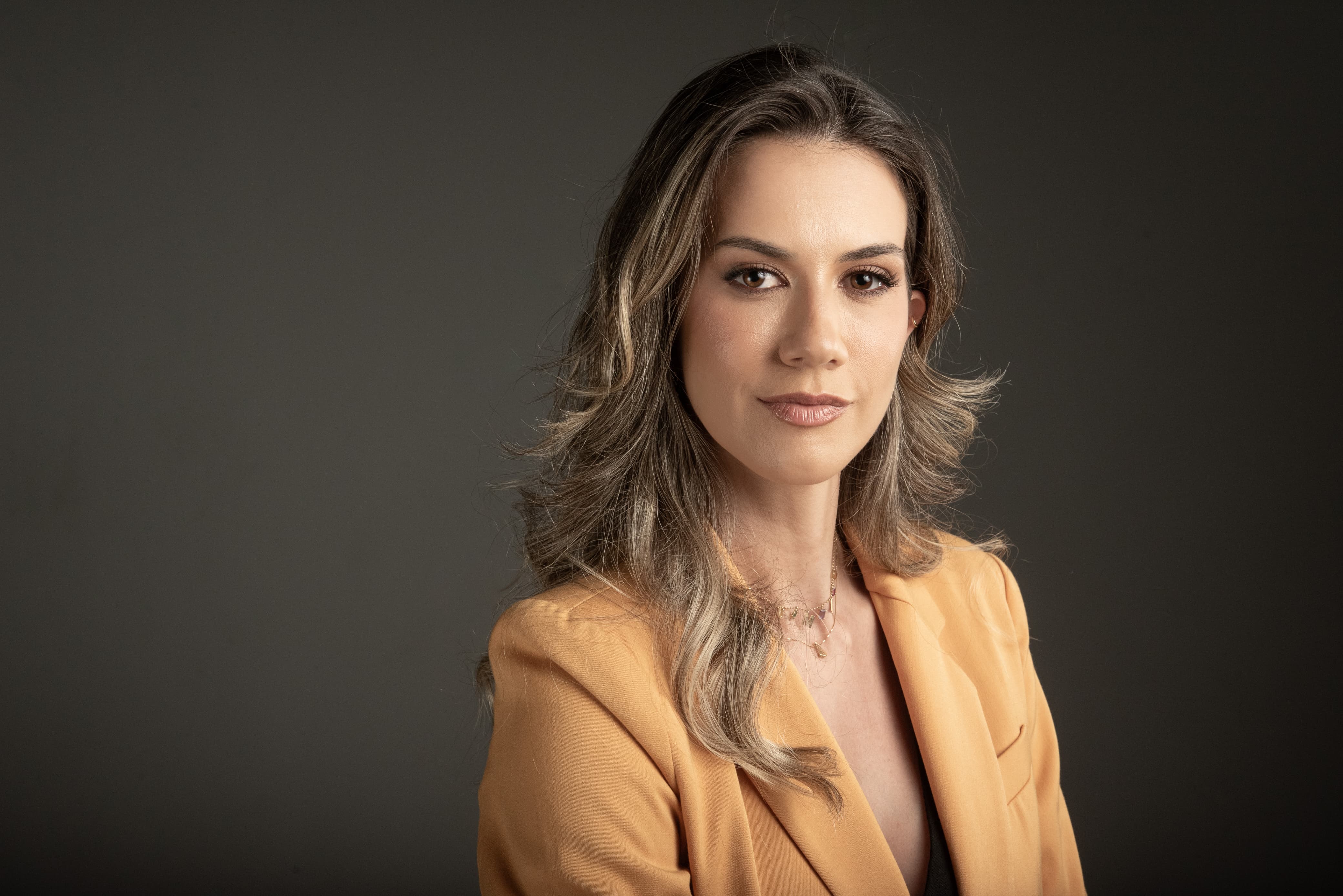 woman in blue tank top standing beside white wall