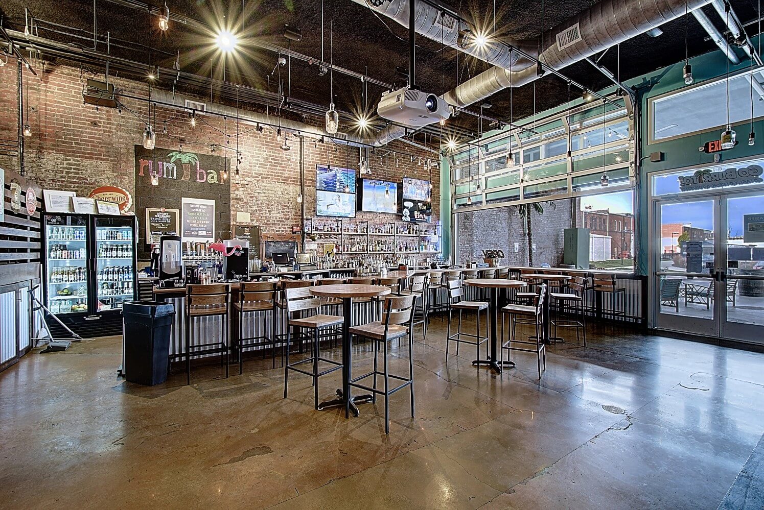 A spacious interior of a modern café with seating, large windows, and bright lighting.
