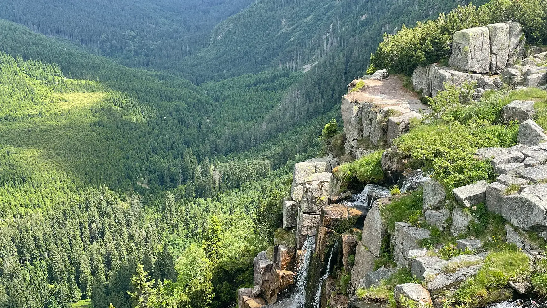 Horský vodopád padající do údolí. Příroda jako inspirace pro dokument o hudbě a vodě v krajině.