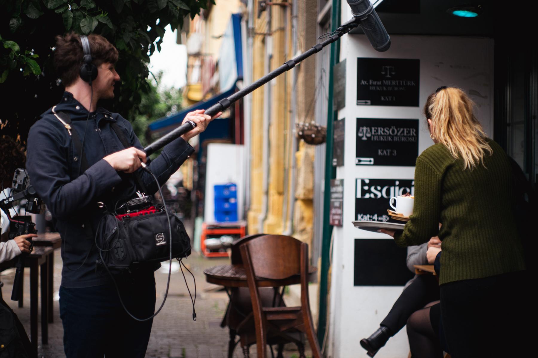 A person wearing a reflective metal protective suit and helmet with a gold-tinted visor, likely in an industrial or high-heat environment.